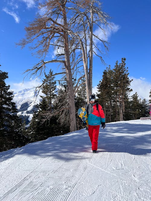 A person walking down a snowy slope with skis