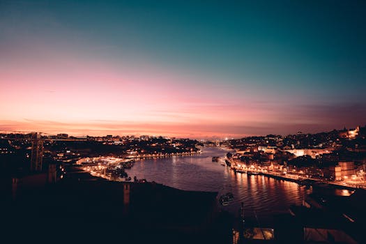 Breathtaking twilight cityscape of Porto with Douro River under a vibrant sky.