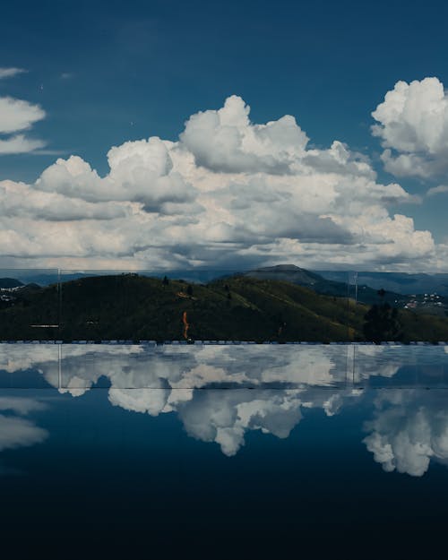 A reflection of clouds and mountains in a pool