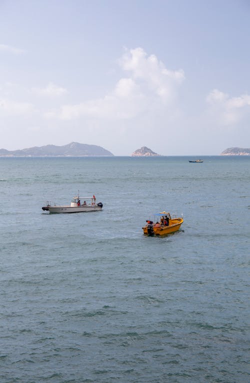 Бесплатное стоковое фото с вертикальный выстрел, море, моторные лодки