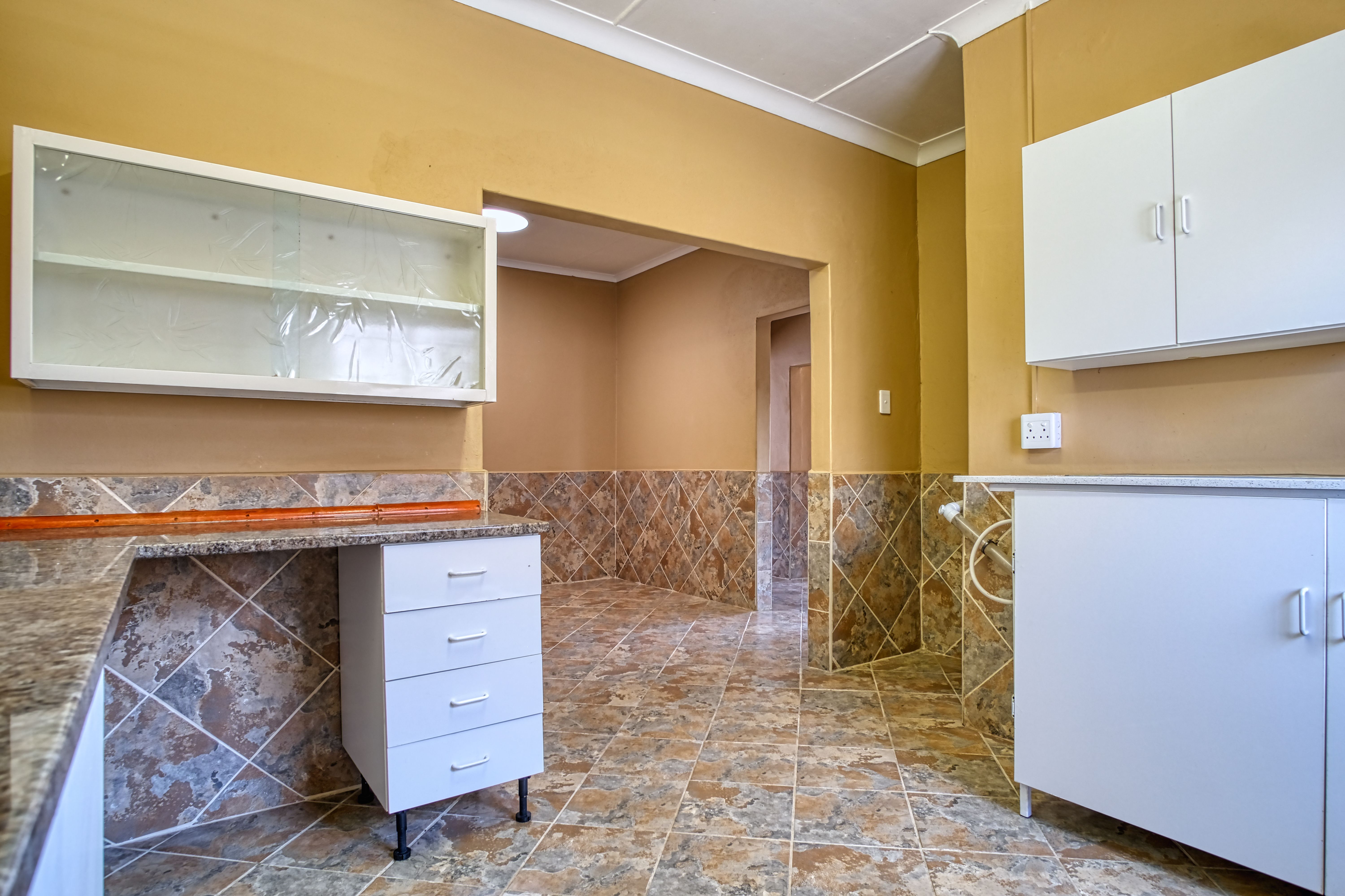 A bright renovated bungalow kitchen with new cabinets and flooring