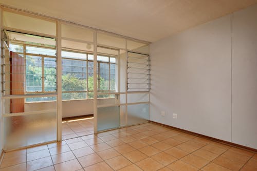 An empty room with tile floors and windows