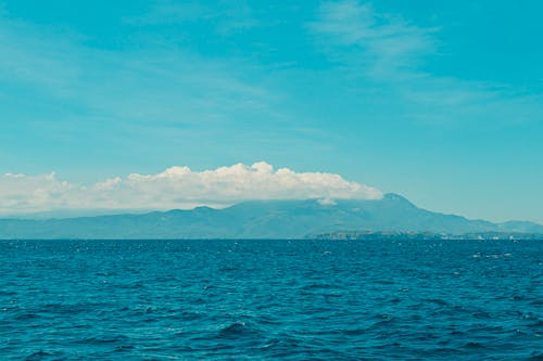 A boat is in the water with a mountain in the background