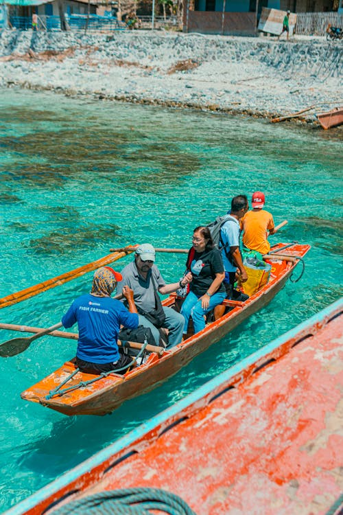 A group of people in a small boat in clear water