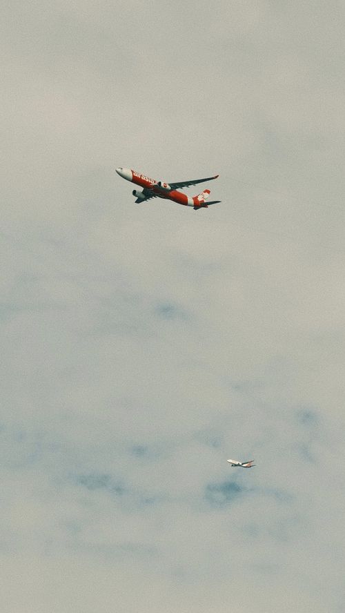 Free Two airplanes flying against a cloudy sky, capturing aerial travel essence. Stock Photo