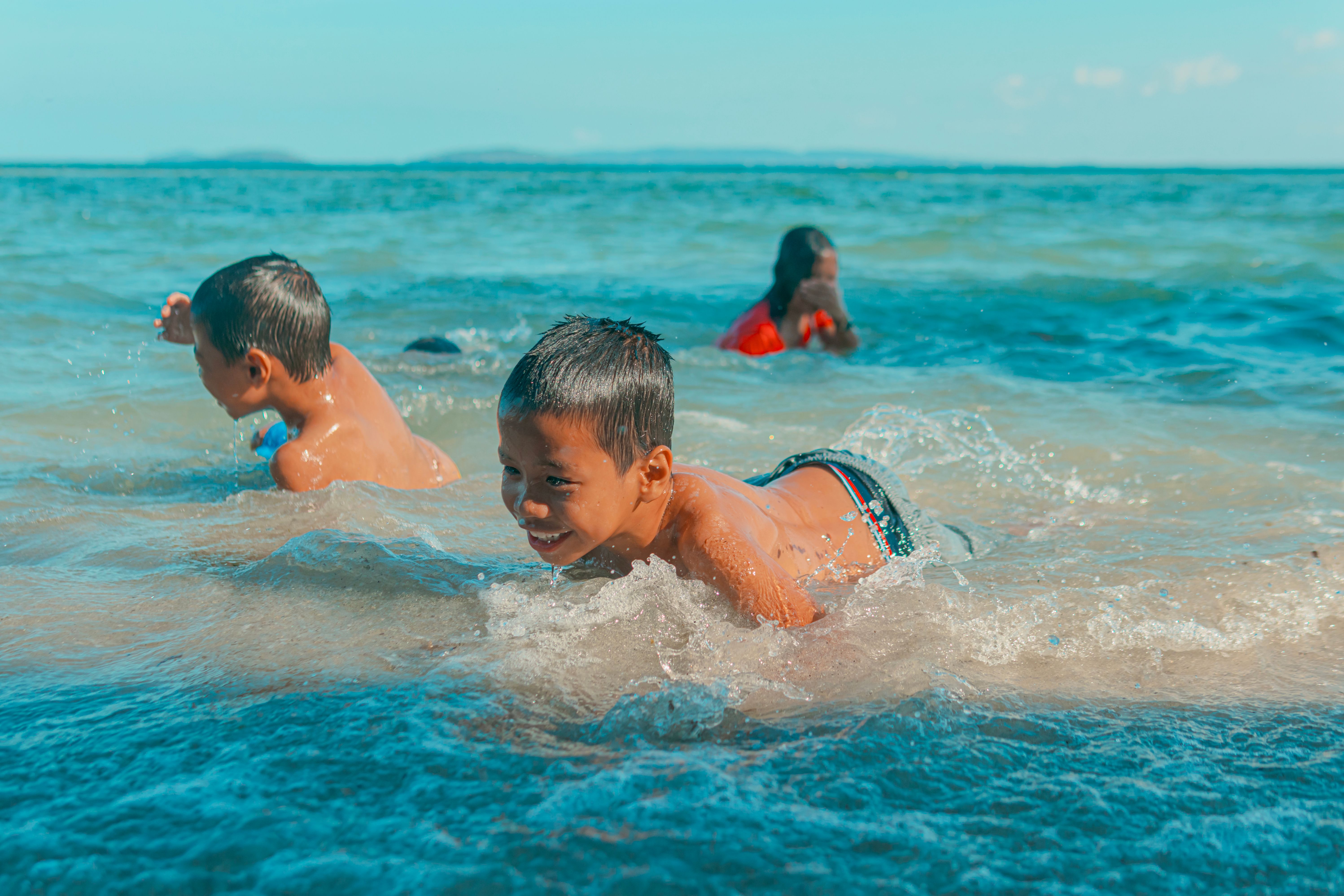 Boy Smiling While Swimming in the Sea · Free Stock Photo