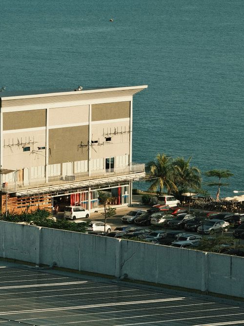 Free A seaside building overlooking a parking lot with a scenic view of the ocean at Port Dickson. Stock Photo