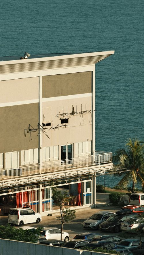Free A modern building overlooking the sea with a parking lot in Port Dickson, Malaysia. Stock Photo