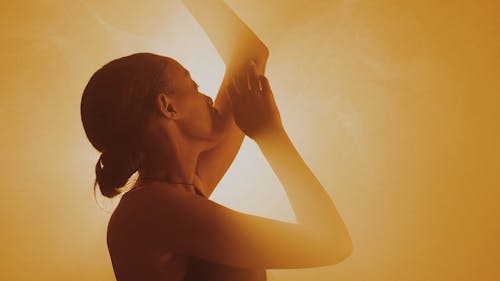 A woman is standing in front of a yellow light