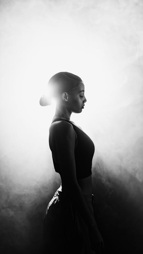 A woman in silhouette standing in front of a foggy light