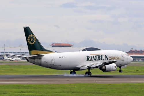 Free Rimbun Cargo airplane touching down on a runway with visible tire smoke. Stock Photo