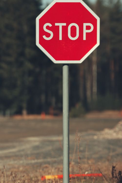 Free Close-up of a red stop sign with forest background in Jönköping, Sweden. Stock Photo