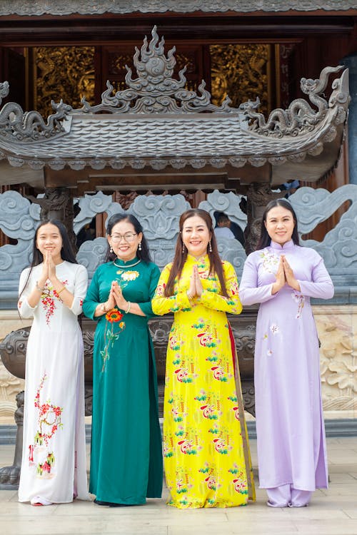 Four women in traditional vietnamese clothing pose for a photo