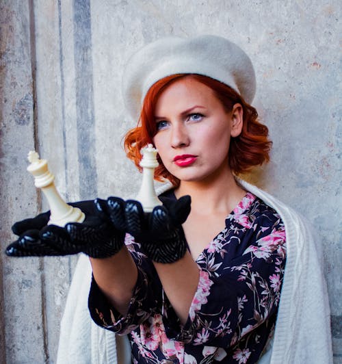 Redhead Woman in Beret Standing with Chess Pieces