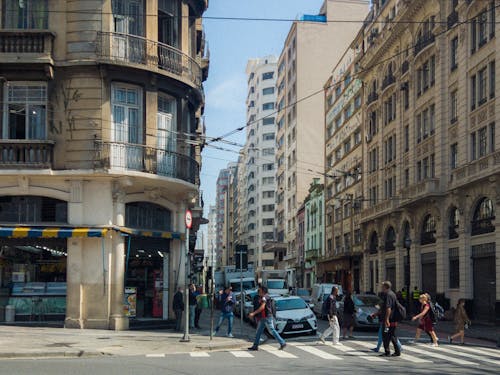 People walking on a city street in front of buildings