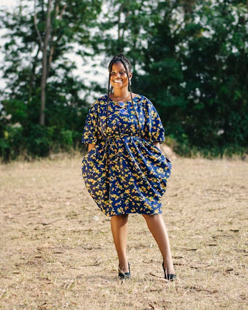 A woman in a blue and yellow dress standing in a field