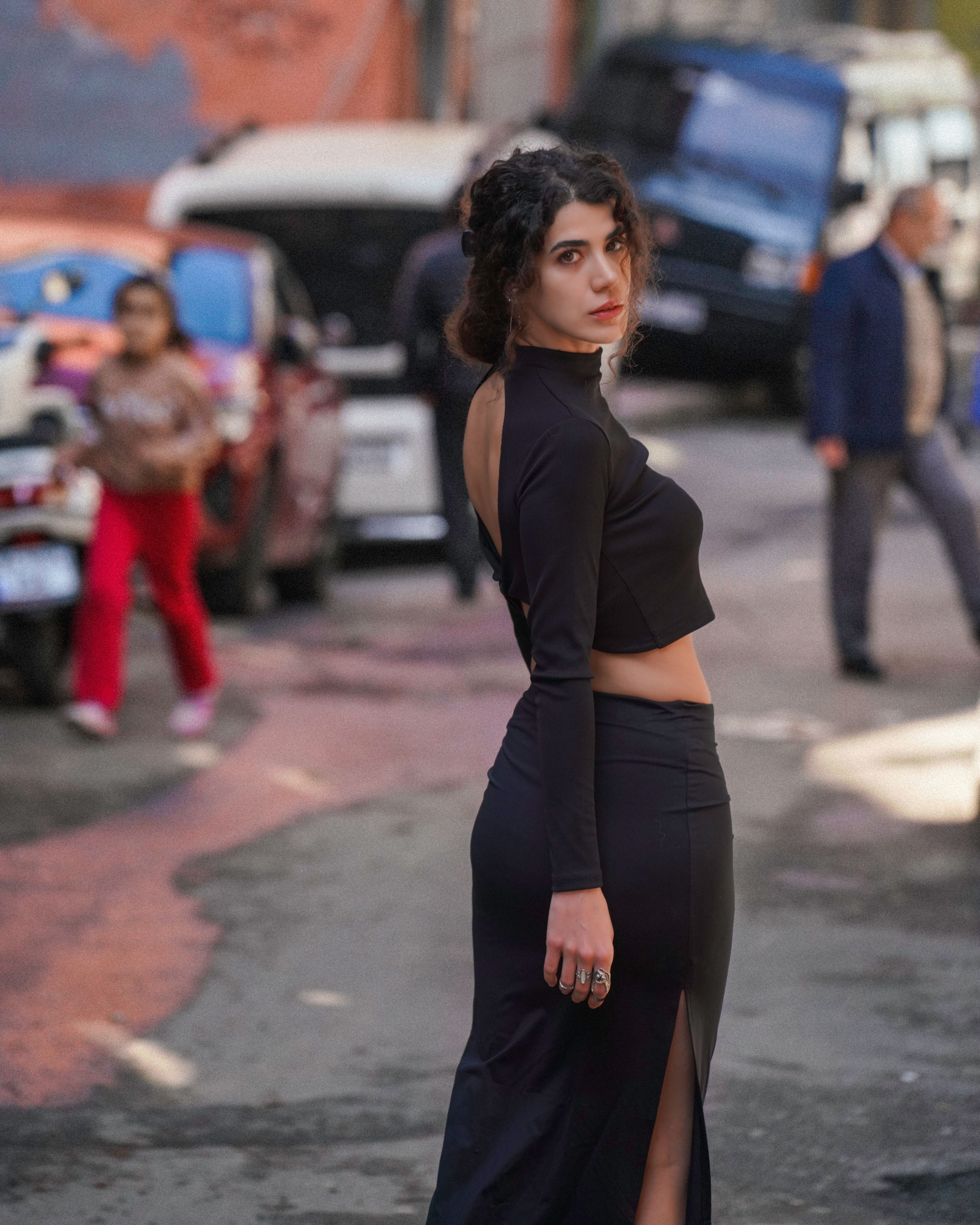 A woman in a black dress standing on a street · Free Stock Photo