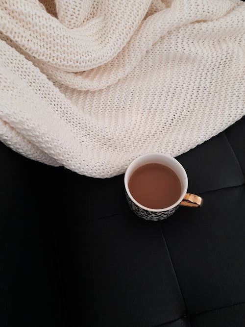 A cup of tea on a black leather couch