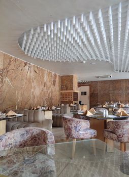 Spacious luxury restaurant with marble walls and ceiling design in Ahmedabad, India.