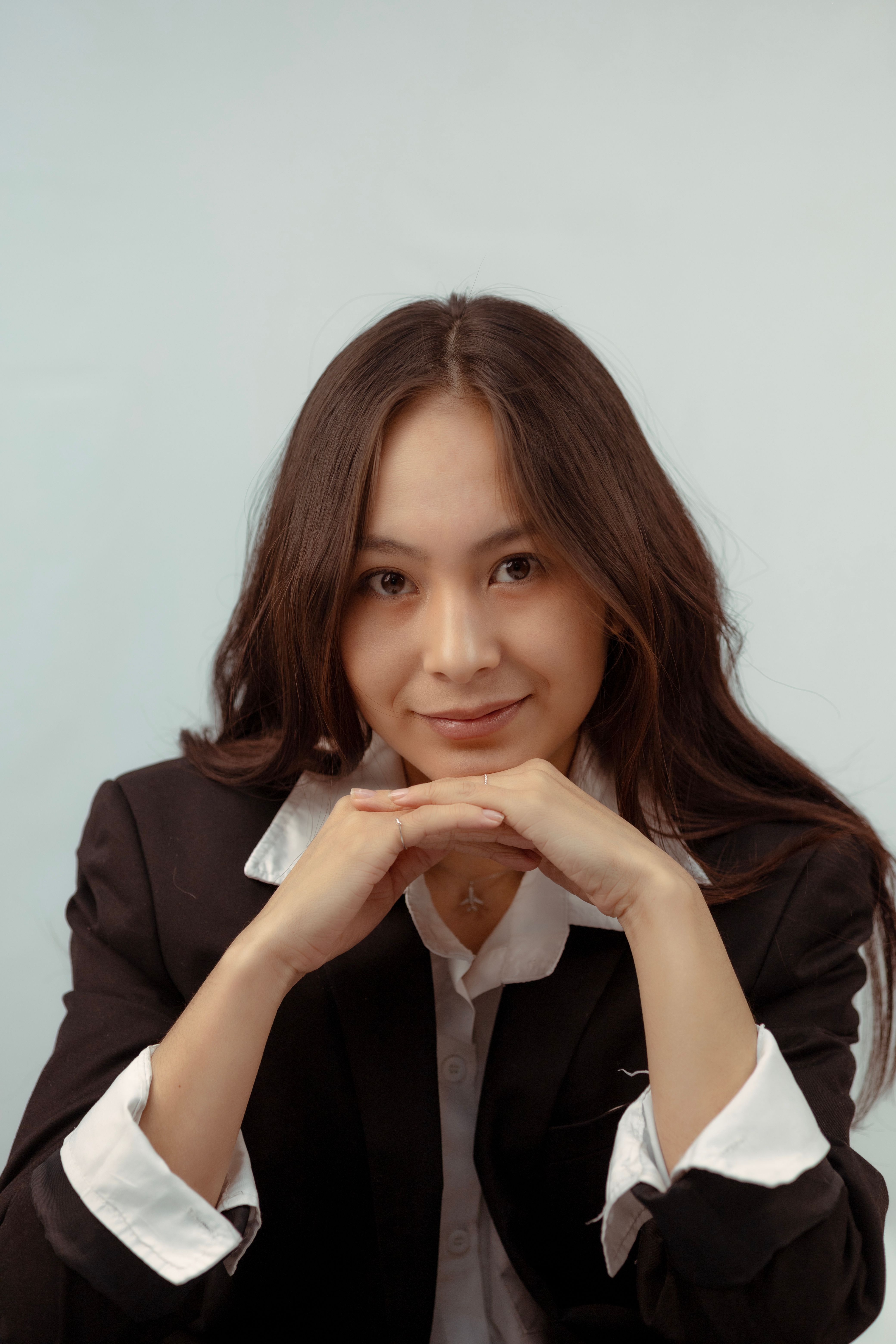 Portrait of an elegant businesswoman smiling in a studio in formal attire. Perfect for corporate use.