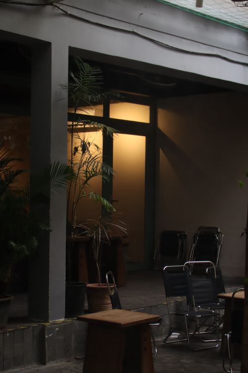 Free Intimate view of an urban courtyard with chairs, plants, and warm lighting. Stock Photo