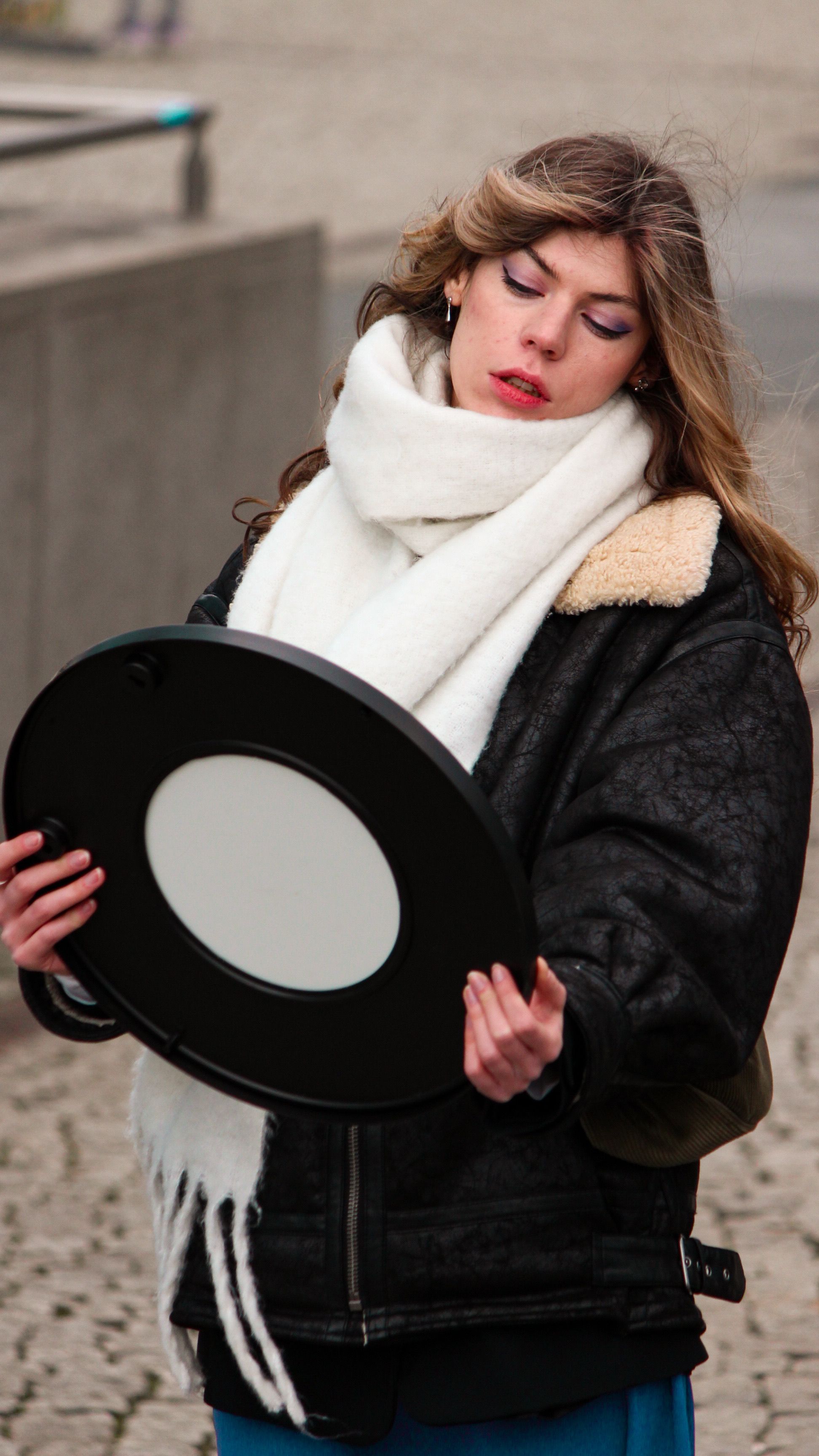 Young Woman in a Jacket and Scarf Standing on a Sidewalk · Free Stock Photo