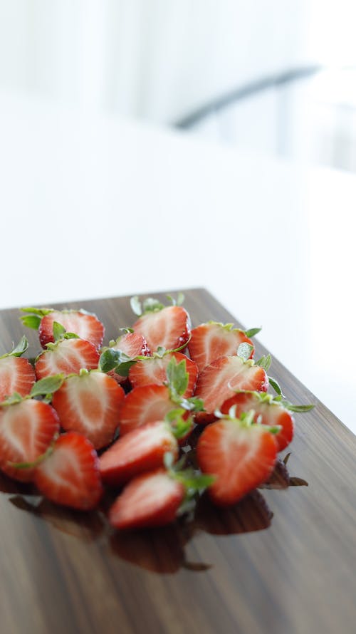 A wooden cutting board with strawberries on it