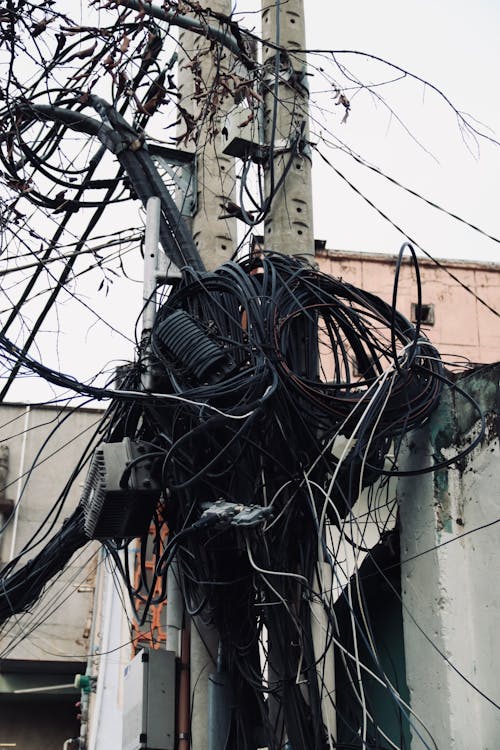 A street with many wires hanging from a pole