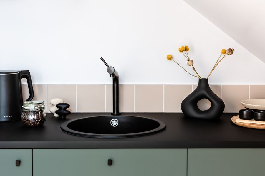 Minimalist kitchen with black faucet and styled counter