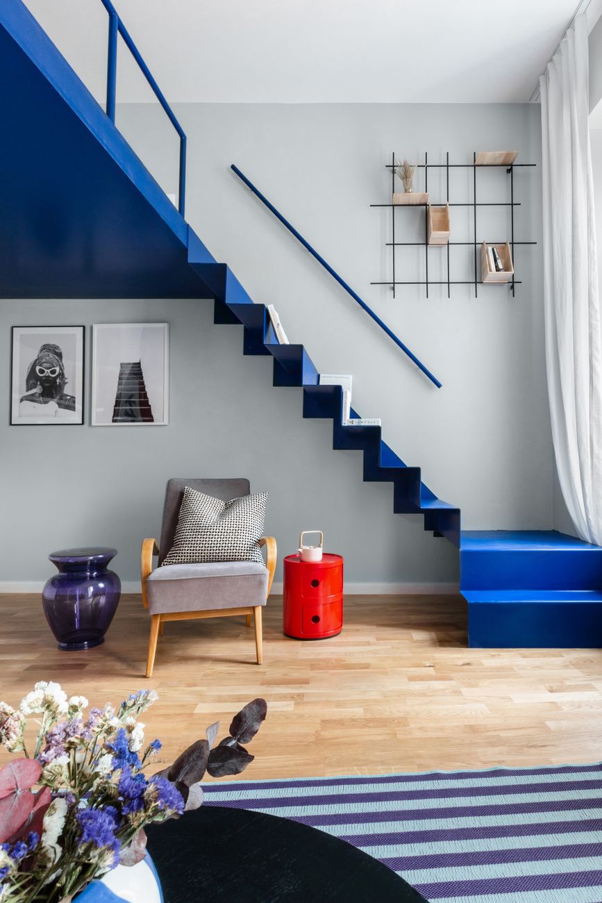 Modern living room featuring a striking blue staircase and stylish decor elements.
