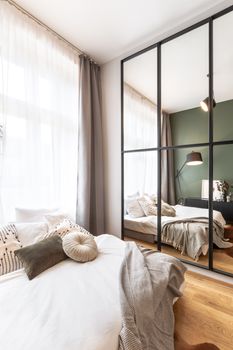 Contemporary bedroom in Prague features large mirrors and soft textiles for a cozy ambiance.