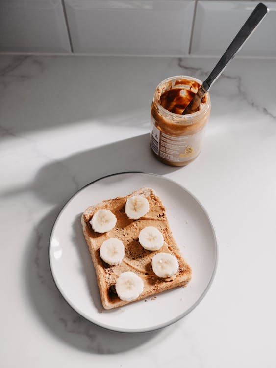 A plate with a piece of toast and peanut butter