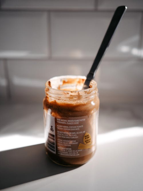 A jar of peanut butter with a spoon in it