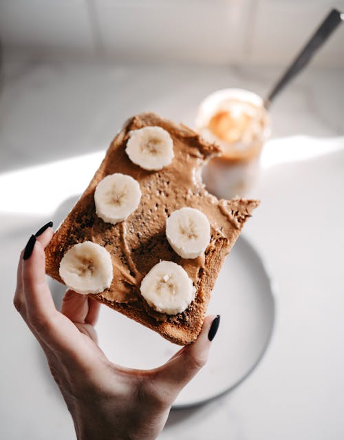 Free Close-up of a Woman Holding a Peanut Butter and Banana Toast Stock Photo