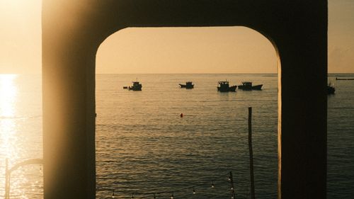 Free Idyllic sunset at Phu Quoc with silhouetted boats and a golden sea view. Stock Photo
