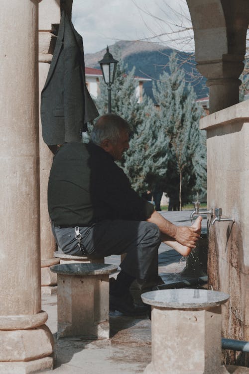 A Man Washing His Feet before Entering a Mosque