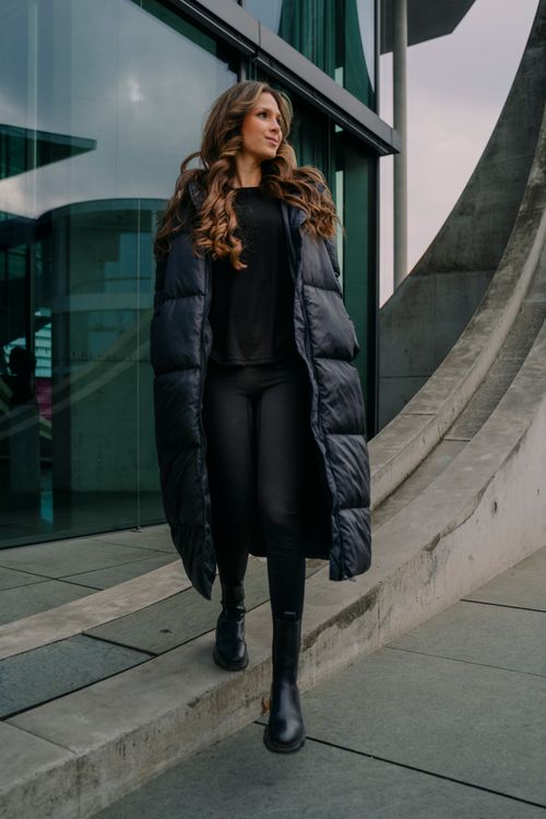 Free Fashionable woman in Berlin walking by modern architecture, exuding urban style and confidence. Stock Photo