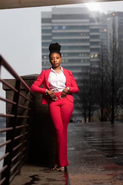 A woman in a pink suit standing on a bridge