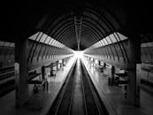 这张现代火车站内部的戏剧性黑白照片，线条对称，站台空无一人
