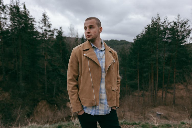 Fashionable Man In A Checkered Shirt And Brown Jacket Standing Outside 