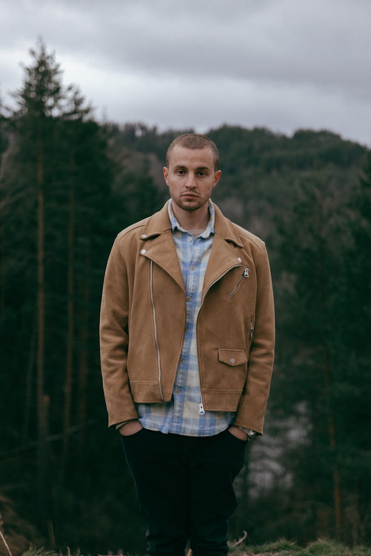 Fashionable Man In A Checkered Shirt And Brown Jacket Standing Outside 