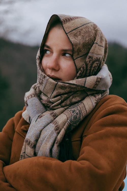 Young Woman in a Brown Jacket and a Scarf Standing Outside 