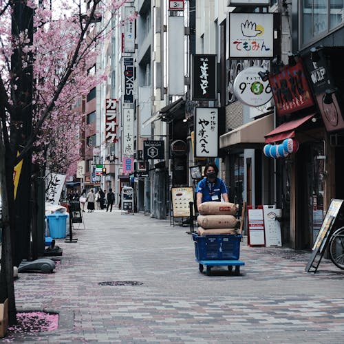 A man pushing a cart down a city street