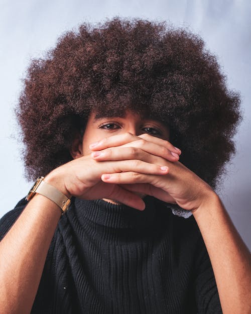 A man with an afro covering his face