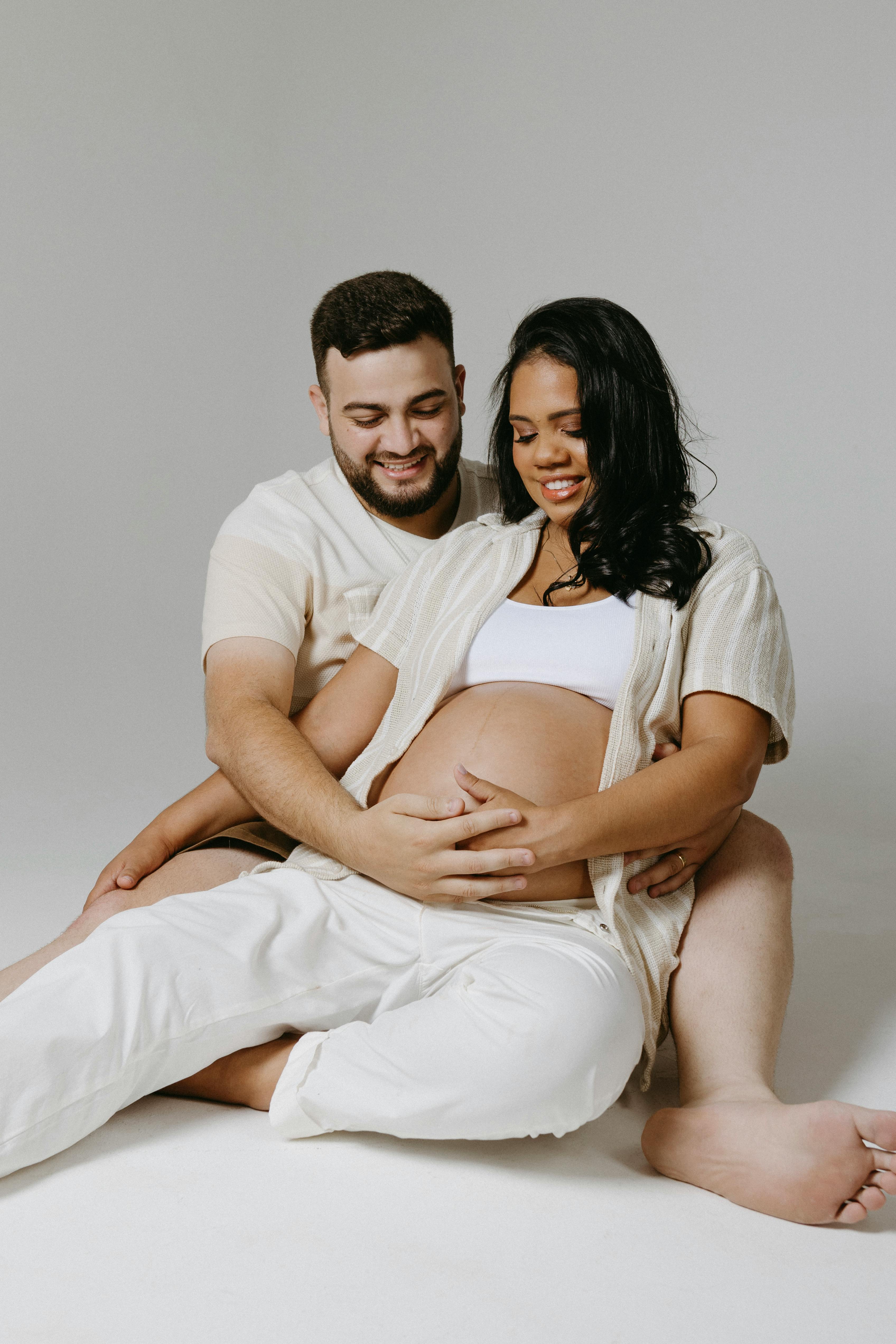 couple expecting a baby posing in a studio