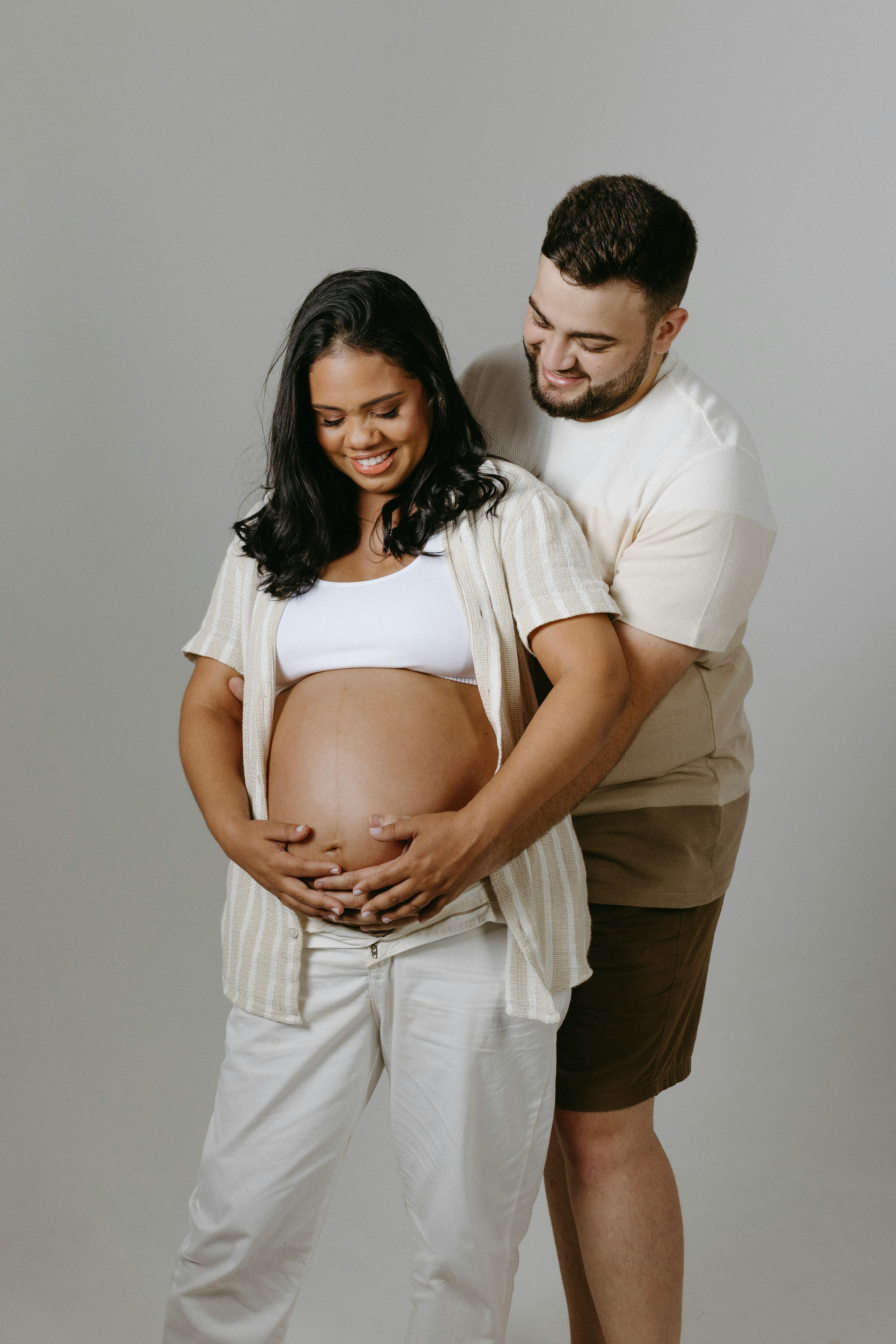 couple expecting a baby posing in a studio