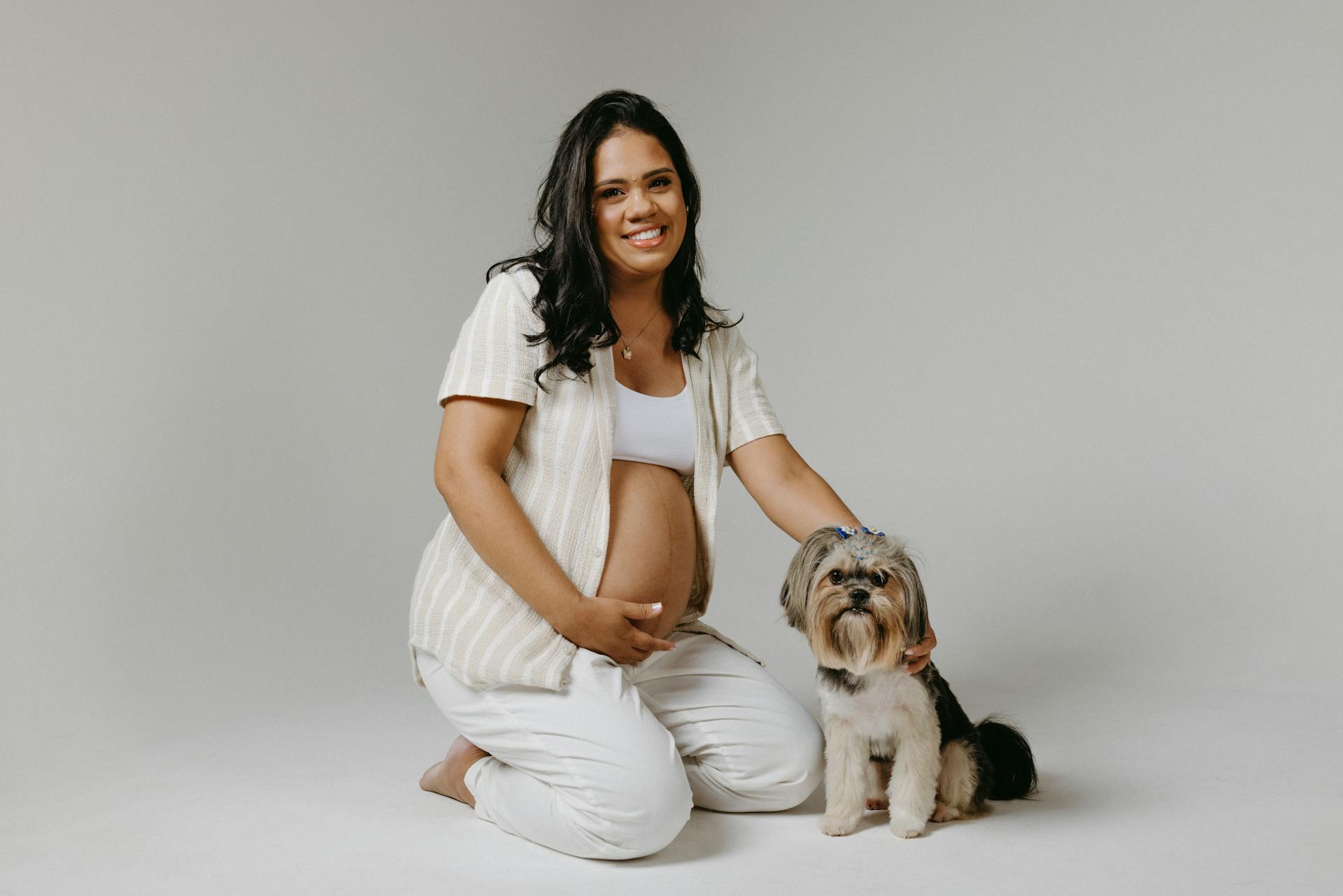 Pregnant Woman Posing in a Studio with a Dog