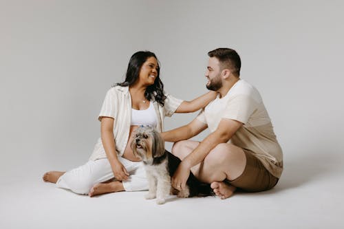 Couple Expecting a Baby Posing in a Studio with a Dog