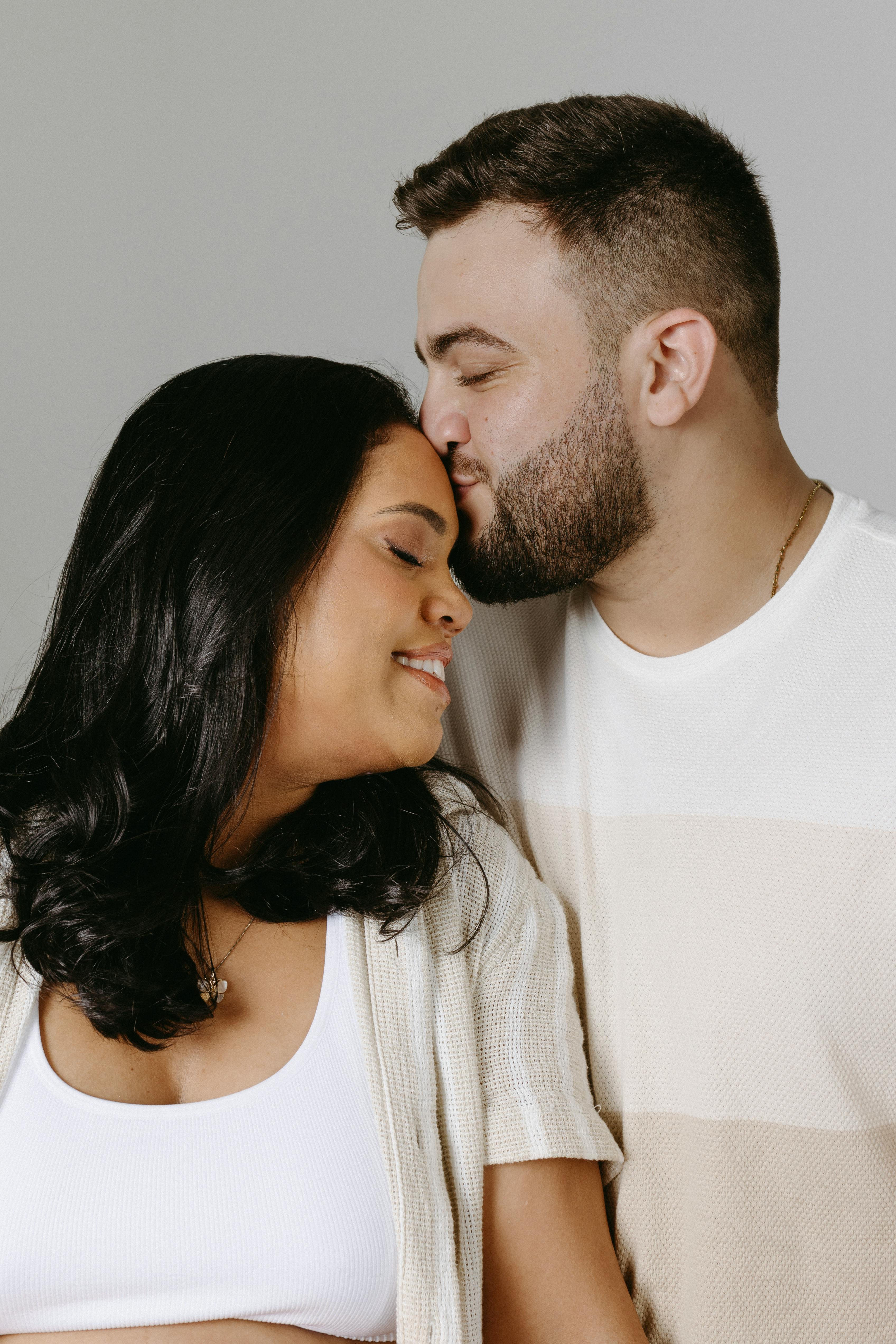 couple expecting a baby posing in a studio