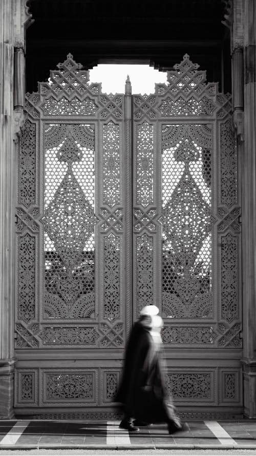 A man walking through a doorway with ornate doors